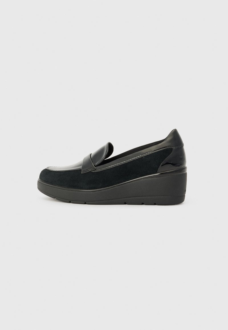 Chaussure slip-on en Suède noire avec un accent en cuir verni noir brillant, semelle compensée et un design de bout arrondi et lisse.
