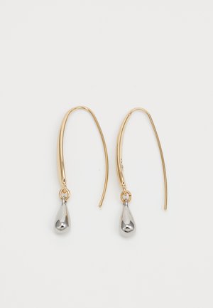Gullhook-øreringer med små sølvdråpeformede anheng på en ensfarget hvit bakgrunn.