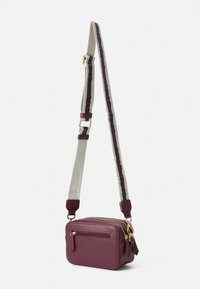 Sac en cuir bordeaux à bandoulière avec une sangle ajustable assortie. Présente des accessoires en métal doré et une poche zippée à l'avant. Forme rectangulaire.