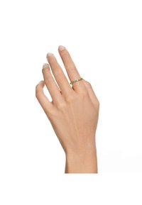Gold ring with green stones, featuring a slim band design. The hand displays a natural pose with neatly manicured nails.