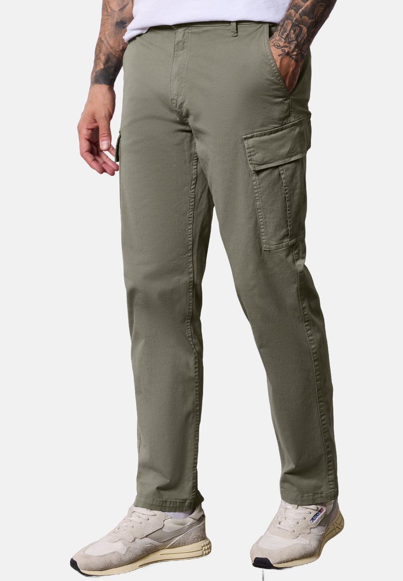 Pantalones cargo en verde oliva con un corte recto, que cuentan con bolsillos laterales y una tela suave y ligera. Combinados con zapatillas beige.