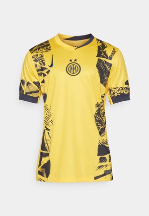 Camiseta de fútbol amarilla con patrones abstractos en negro, mangas cortas y diseño de cuello en V. Presenta un logo en el centro y un cuello en contraste.