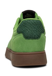 Zelene suède tenisice s teksturiranim zelenim sintetičkim stražnjim dijelom, smešnim gumenim potplatom i šivenim detaljima. Sadrže podstavljen ovratnik za udobnost.