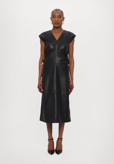 Robe en cuir noir avec un col en V, des manches courtes et à capuche, et des côtés réglables à cordon. Présente une silhouette cintrée et un ourlet au niveau des genoux.