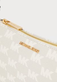 Custodia in tessuto bianco con motivo a logo MK in rilievo, zip dorata e marchio Michael Kors. Texture liscia con una leggera lucentezza.