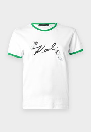 Biely bavlnený tričko s zeleným rebrovaným golierom a rukávmi. Obsahuje čierne písané meno "Karl" a dvoch ilustrovaných psov v slnečných okuliaroch.