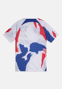 Camiseta deportiva de manga corta con una base blanca y patrones gráficos abstractos en azul y rojo, con acentos azules en los hombros.