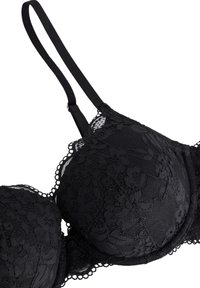 Sorte blonde-bh med polstrede skåle, blomster mønster og bølgede kanter. Har justerbare stropper og en hægteslutning bagpå.
