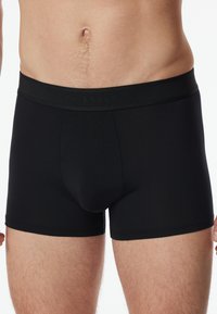 Svarta boxershorts i mjukt tyg med en bred resår i midjan som är präglad med varumärkesnamnet. Erbjuder en åtsittande passform med sömdetaljer.