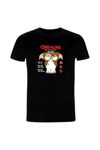 Sort bomulds-T-shirt med et tegneserie-gremlin og tekst, der angiver tre regler i rødt og hvidt. Rund hals og korte ærmer.