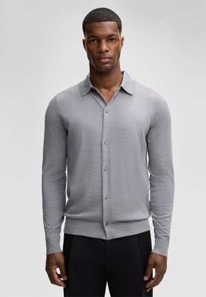 Gray long-sleeve button-up shirt with a collar, made of textured fabric. Features a front placket with buttons and ribbed cuffs.