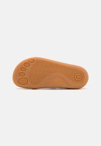 Semelle de chaussure barefoot, en caoutchouc flexible, couleur marron clair, texturée avec des motifs en zigzag et à points. Marquée avec "frodo" et taille 26.