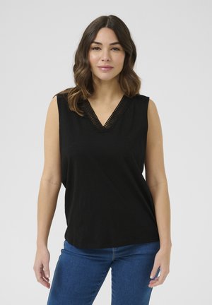 Haut sans manches noir avec un décolleté en V présentant une bordure en crochet texturé. Fabriqué à partir d'un matériau doux ; coupe décontractée. Associé à un jean bleu.