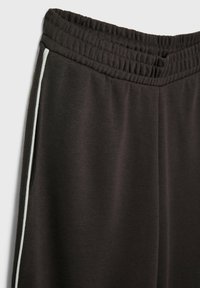 Donkergrijze sweatpants met een elastische tailleband, voorzien van een witte zijstreep. Gemaakt van zachte, rekbare stof met een gladde textuur.