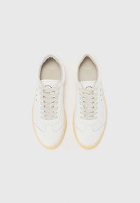 Adidași din piele albă cu o finisare netedă, având șireturi rotunde, o talpă din cauciuc de culoare deschisă și un logo minimalist pe limba adidasului.