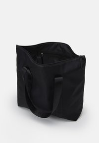 Borsa tote nera realizzata in tessuto testurizzato, con doppie maniglie nere, tasca interna con zip e design a apertura superiore.