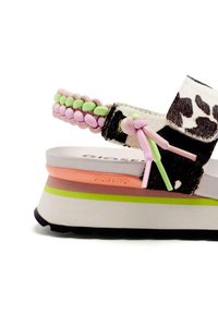 Sandalia de estampado de vaca en blanco y negro con una tira trenzada en rosa y verde, con una suela en capas en rosa, crema y verde, marcada "Gioseppo."