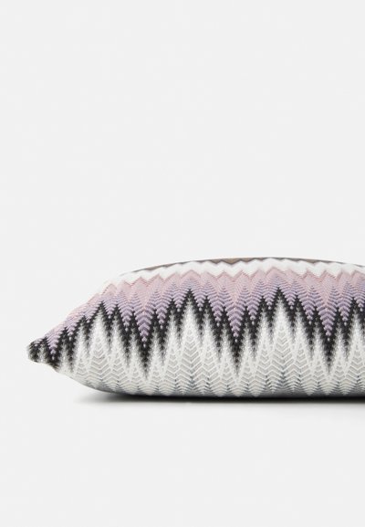 Woven cushion featuring a zigzag pattern in shades of pink, black, and white, with a soft texture and rectangular shape.