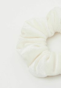 Bílý saténový scrunchie s texturovaným lesklým povrchem, s nasbíranou tkaninou vytvářející kruhový tvar. Jednoduchý a elegantní design.