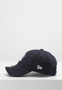 Cappellino da baseball blu navy con visiera curva, caratterizzato da un logo ricamato bianco sul davanti e una parte interna con un motivo a contrasto.