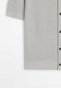 Cardigan court en maille gris clair à manches courtes avec fermeture à boutons sur le devant et poignets et ourlet côtelés.