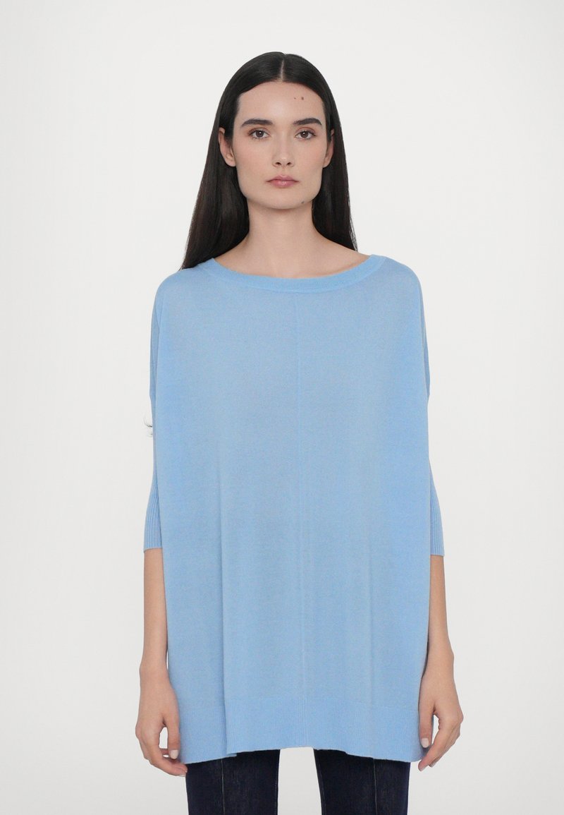 Pulover supradimensionat de culoare albastră deschis, din tricot, cu decolteu rotund, mâneci de trei sferturi și detalii din jerseu la manșete și tiv.