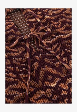 Brown and maroon tie-dye fabric with smocked texture features a tied bow over a mesh panel with white stitching.