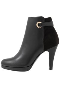 Musta nilkkurit korkokengällä, joissa on sileä nahkapinta, mokkanahkainen takapaneeli, pyöreä kultainen koriste ja teräväkärkinen muotoilu.