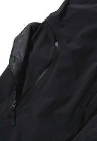 Jachetă neagră dintr-o țesătură netedă, rezistentă la apă, cu un buzunar cu fermoar unghiular dotat cu un fermoar texturat și elemente de design minimaliste.