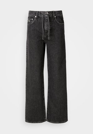 Sorte vidde jeans laget av denim. Har høy midje, beltehemper, frontlommer og detaljer i sølvmetall.