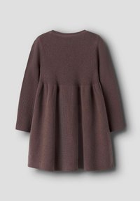 Strikket kjole i mørk mauve, med lange ærmer og en tætsiddende overdel, der brede ud til en flagrende nederdel. Struktureret ribbet design gennem hele kjolen.