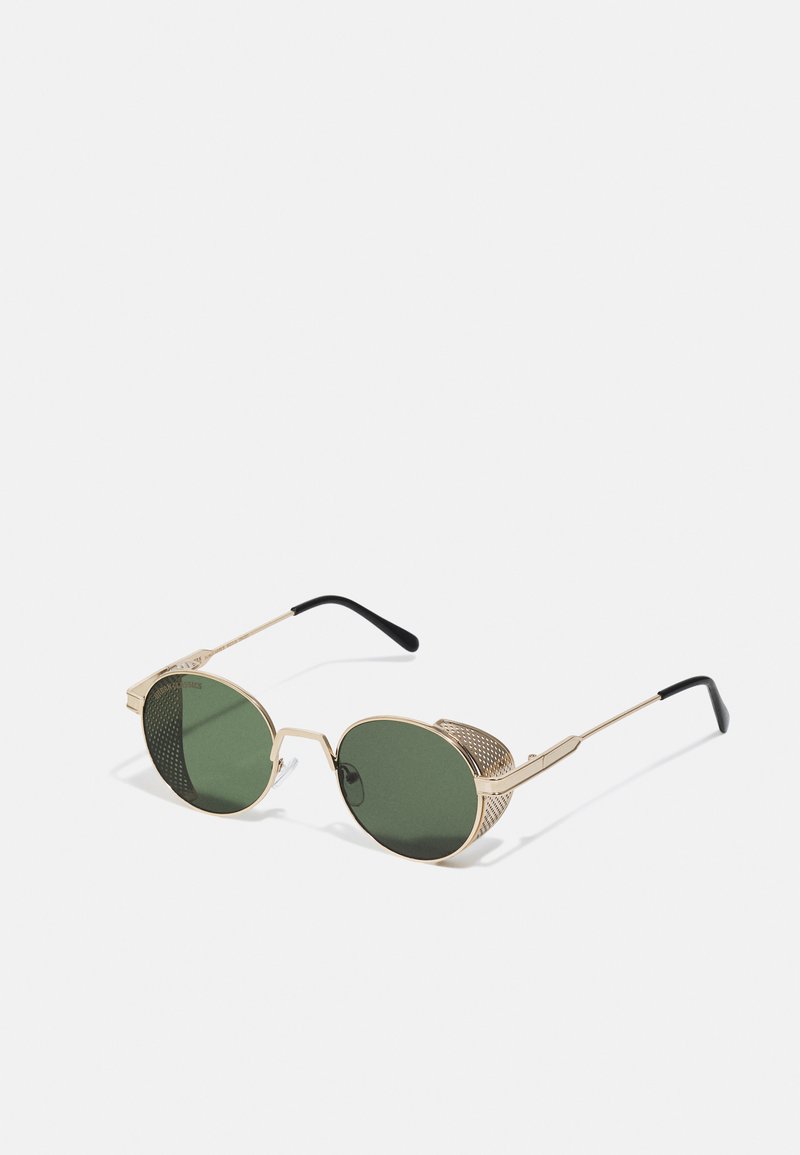 Lunettes de soleil en métal doré avec des verres verts, dotées d'un détail en maille unique sur les côtés et de branches fines accentuées de noir. Design à monture ronde.