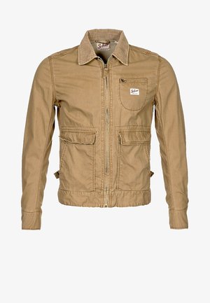 Kaki kurtka na zamek wykonana z bawełny, z dwiema kieszeniami z przodu oraz kieszenią na klatce piersiowej. Posiada kołnierz i wyhaftowane akcenty.