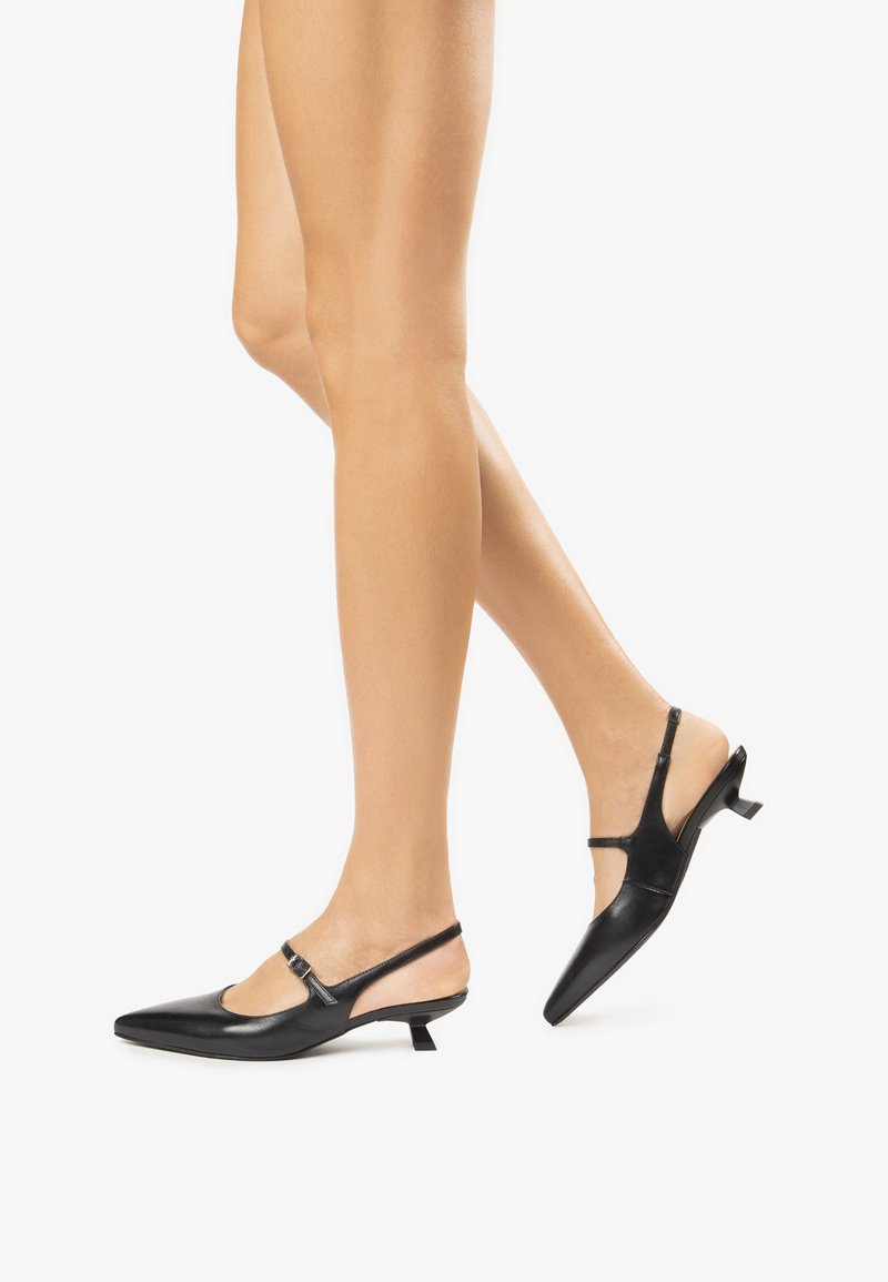 Sorte slingback sko med spids tå, lav kitten hæl, lædermateriale og en tynd ankelrem for sikker pasform.