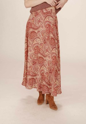 Jupe maxi en tissu doux avec un motif paisley rouge et beige, dotée d'un design fluide et d'un ourlet qui s'évase légèrement en bas.