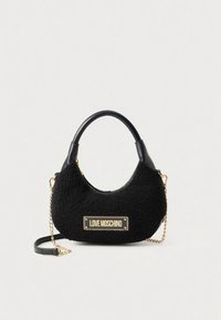 Black handbag featuring a textured fur-like material, curved shape, dual handles, and a gold-tone logo plaque. Includes a removable chain strap.