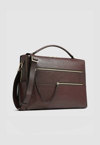 Donker bordeaux leren tas met twee voorvakken met rits, een bovenhandvat en een verstelbare schouderriem. Gestructureerd oppervlak met gouden details.