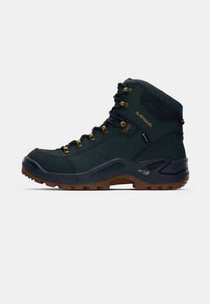 Bota de senderismo verde oscuro con suela negra y marrón, ojales de metal, cuello acolchado en el tobillo y marcas visibles de Lowa y Gore-Tex en el lateral.