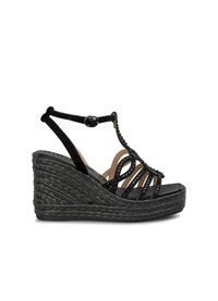 Sandalo nero con zeppa, tacco intrecciato, cinturini con borchie e fibbia alla caviglia regolabile. Texture liscia con linee verticali e design aperto.