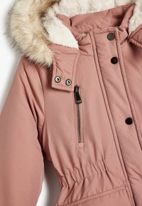 Giacca isolata rosa con cappuccio foderato in pelliccia sintetica, tasca con zip, bottoni a pressione e vita elastica per una forma aderente.