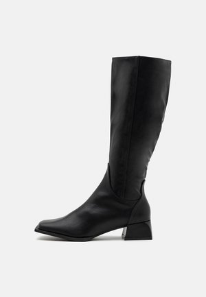 Bottes noires montantes en cuir lisse, avec un bout rond, un petit talon et un design épuré et ajusté sans embellissements.