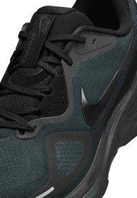 Musta ja tummanturkoosi urheilukenkä, jossa on teksturoitu yläosa, saumaton muotoilu, nauhoitusjärjestelmä ja näkyvä musta Swoosh-logo.