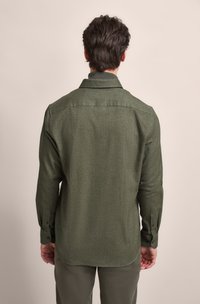 Olive green button-up shirt made from a textured fabric, featuring a pointed collar and long sleeves with buttoned cuffs.