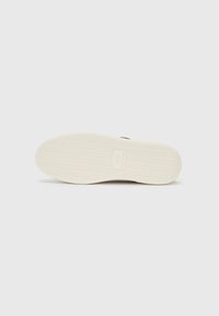 Gummisåle med teksturert mønster. Kremfarge med fiskebeinmønster for grep. Har merkets logo preget i midten.