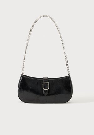 Sac à épaule en cuir verni noir avec détail de boucle argentée et bandoulière en chaîne argentée, présenté sur un fond uni clair.