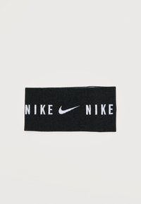Μαύρη υφασμάτινη αθλητική κορδέλα με λευκό λογότυπο Nike και την επιγραφή "NIKE" επαναλαμβανόμενη και στις δύο πλευρές.