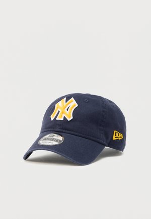 Navy blue cap made of cotton with a white and yellow embroidered logo on the front. Adjustable strap at the back. Curved brim design.