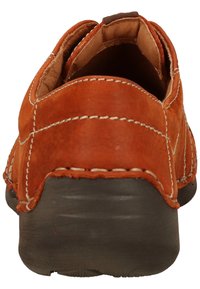 Scarpa slip-on in pelle marrone con cuciture bianche, punta arrotondata e suola in gomma testurizzata. Il tacco è leggermente elevato e arrotondato.