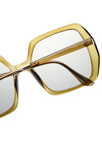 Převelké sluneční brýle s průhledným světle hnědým a tmavě hnědým rámem, zdobené geometrickými tvary a čirými skly.