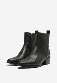 Botas de cuero negro hasta el tobillo con textura de cocodrilo, puntera puntiaguda, tacón bajo y paneles laterales elásticos para facilitar su uso.